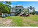 Inviting exterior featuring lush green lawn, mature trees and well-maintained landscaping, enhancing the home's curb appeal at 423 Lake Moultrie Dr, Bonneau, SC 29431
