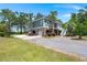 Stunning elevated home with a brick facade, palm trees, and multiple garage spaces at 423 Lake Moultrie Dr, Bonneau, SC 29431