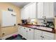 Well-organized laundry room features white cabinets, wood countertops, a sink, and pegboards for efficient storage solutions at 423 Lake Moultrie Dr, Bonneau, SC 29431