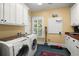 Modern laundry room equipped with Bosch washer and dryer, white cabinets, and wood countertops, complemented by bright natural light at 423 Lake Moultrie Dr, Bonneau, SC 29431