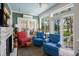 Cozy sunroom features colorful seating and a fireplace with a stone surround and water views at 423 Lake Moultrie Dr, Bonneau, SC 29431