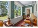 Relaxing sunroom with large windows, a comfortable couch, and serene water views at 423 Lake Moultrie Dr, Bonneau, SC 29431