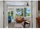 Bright sunroom with a ceiling fan, an oversized leather chair, and views of the water and trees at 423 Lake Moultrie Dr, Bonneau, SC 29431
