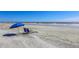 Beach chairs under a bright blue umbrella, providing a comfortable spot on the sandy shore at 4233 Mariners Watch, Johns Island, SC 29455