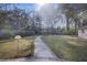 Spacious backyard with a scenic walkway leading to a pergola surrounded by mature trees and lush greenery at 4765 S Constellation Dr, North Charleston, SC 29418