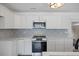 Close up of a kitchen featuring white cabinets, stainless steel appliances, and designer backsplash at 4765 S Constellation Dr, North Charleston, SC 29418