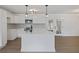 All-white kitchen with stainless appliances, central island, pendant lights, and stylish tiled backsplash at 4765 S Constellation Dr, North Charleston, SC 29418