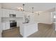Bright kitchen boasts stainless steel appliances, white cabinets, an island, and stylish pendant lighting at 4765 S Constellation Dr, North Charleston, SC 29418