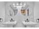 Bright bathroom featuring double pedestal sinks, round mirrors, and modern fixtures, offering a stylish and functional space at 5 Mariners Cay Dr, Folly Beach, SC 29439