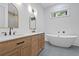 Modern bathroom with double vanity, marble countertop, and a freestanding soaking tub under a window at 5105 St George Ln, Hollywood, SC 29449