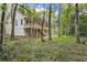 Beautiful exterior view of a two-story home with a deck, surrounded by lush greenery at 5105 St George Ln, Hollywood, SC 29449