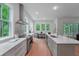 Open kitchen with stainless appliances, hardwood flooring, quartz counters, and bright windows at 5105 St George Ln, Hollywood, SC 29449