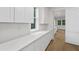 Pantry area boasts plentiful cabinetry and quartz countertops with windows offering natural light at 5105 St George Ln, Hollywood, SC 29449