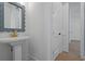 Traditional powder room features a pedestal sink with brass faucet and large scallop-edged mirror at 5105 St George Ln, Hollywood, SC 29449