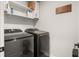 Laundry room with modern washer and dryer units and upper storage shelves at 514 Shady Maple St, Moncks Corner, SC 29461