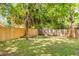 Large backyard featuring a wooden fence providing privacy, lush green grass, and mature trees at 5155 Monterey St, North Charleston, SC 29405