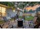Picturesque backyard featuring a fire pit, outdoor seating, a grill, and a grassy area with ambient string lights at 5155 Monterey St, North Charleston, SC 29405
