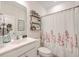 Clean bathroom featuring a sink vanity, toilet, decorative shelf and a shower with a floral curtain at 612 S Pointe Blvd, Summerville, SC 29483