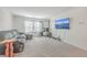 Bright bonus room featuring a grey sofa, fitness equipment, large television, and neutral-colored carpet at 612 S Pointe Blvd, Summerville, SC 29483