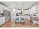 Well-lit kitchen with stainless appliances, white cabinets, center island with stool seating, and hardwood floors at 612 S Pointe Blvd, Summerville, SC 29483