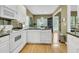 A kitchen with white appliances, cabinets and countertops, plus a seamless flow to dining area at 613 Antebellum Ln, Mount Pleasant, SC 29464