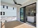 A covered porch with ceiling fan leads via sliding glass doors into a bright kitchen with a white island at 6518 Beagle Club Rd, Meggett, SC 29449