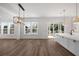 Sunlit open concept living area with wood floors and multiple large windows at 6518 Beagle Club Rd, Meggett, SC 29449