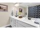 Bathroom featuring a double sink vanity, white cabinetry, and decorative accents at 658 Yellow Leaf Ln, Summerville, SC 29486