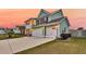 Inviting two-story green home with three-car garage and manicured lawn at 658 Yellow Leaf Ln, Summerville, SC 29486
