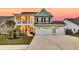 Two-story green home boasts a spacious three-car garage and charming second-story balcony at 658 Yellow Leaf Ln, Summerville, SC 29486