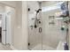 Modern shower with gray tiling, glass door, and built-in shelving for storage at 658 Yellow Leaf Ln, Summerville, SC 29486