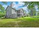 Rear view of a home with a screened porch overlooking a large grassy backyard and pond at 7955 Timbercreek Ln # 1807, North Charleston, SC 29418