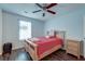Bedroom with wood-look floors, ceiling fan, and bed with red linens and decorative pillows at 7955 Timbercreek Ln # 1807, North Charleston, SC 29418