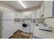 Well-lit kitchen featuring white cabinets, appliances, and durable countertops at 7955 Timbercreek Ln # 1807, North Charleston, SC 29418