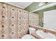 Full bathroom with a tropical themed shower curtain, matching vanity, and ample lighting at 8 Town Park Ln # C, Charleston, SC 29412
