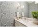 Stylish bathroom with patterned wallpaper, a white vanity, and modern lighting fixtures at 80 On The Harbor Dr, Mount Pleasant, SC 29464