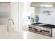 Close-up of modern kitchen appliances with stainless steel hood and professional-grade stove and oven with red knobs at 80 On The Harbor Dr, Mount Pleasant, SC 29464