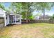 Spacious backyard with a screened-in porch, trees, and some patchy grass at 8451 Walsham St, North Charleston, SC 29420