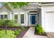 Charming home featuring a light gray exterior, a blue front door, and meticulously landscaped front yard at 8451 Walsham St, North Charleston, SC 29420