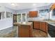 Well-lit kitchen features an island, wood cabinets, and stylish tile flooring, perfect for culinary endeavors at 8451 Walsham St, North Charleston, SC 29420