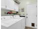 A laundry room with a washing machine, dryer, shelving, and an exterior door at 8451 Walsham St, North Charleston, SC 29420