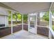 A screened porch featuring a concrete floor, white railings, and a door to the backyard at 8451 Walsham St, North Charleston, SC 29420