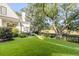 Expansive backyard featuring lush artificial turf, mature trees, and a wrought iron fence at 853 Whispering Marsh Dr, Charleston, SC 29412