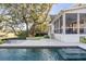 Backyard with a pool, large patio, screened in porch, and mature oak trees providing shade and charm at 853 Whispering Marsh Dr, Charleston, SC 29412