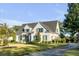 Charming white brick home featuring a manicured lawn and lush, mature trees at 853 Whispering Marsh Dr, Charleston, SC 29412