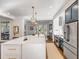 Bright, open kitchen with stainless steel appliances, a white marble island, and chic lighting at 853 Whispering Marsh Dr, Charleston, SC 29412