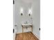 Stylish powder room featuring a marble countertop, brass fixtures and sconces, plus attractive wood flooring at 853 Whispering Marsh Dr, Charleston, SC 29412