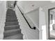 Elegant staircase features herringbone-patterned carpet, black handrail, and white shiplap walls for a modern look at 853 Whispering Marsh Dr, Charleston, SC 29412
