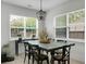Dining room with a dark table, black chairs, and natural light streaming in from large windows at 8703 Jenny Lind St, North Charleston, SC 29406