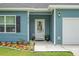 Close-up of home's entrance showcasing a decorative glass door, sidelights, and manicured flower beds at 8703 Jenny Lind St, North Charleston, SC 29406